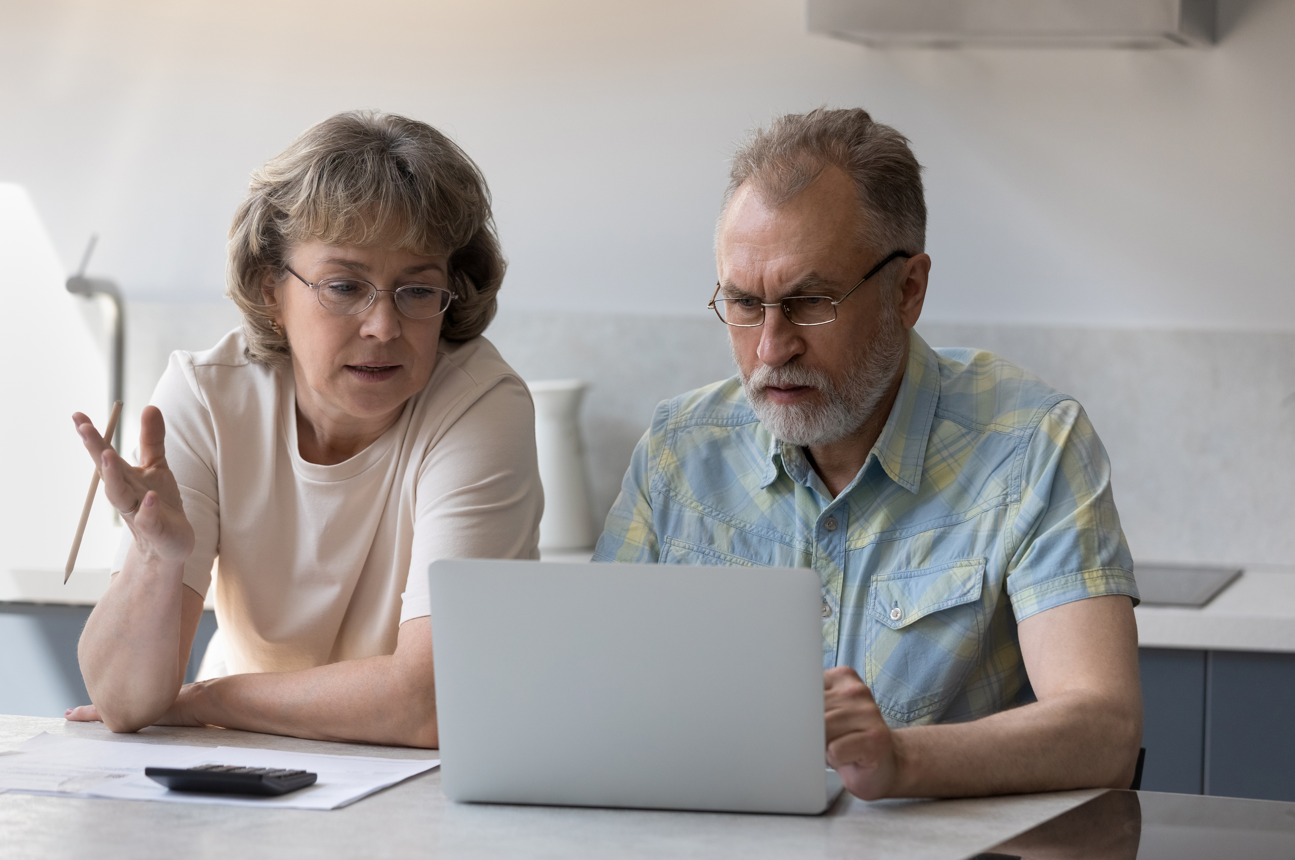 concerned older couple looking at a laptop
