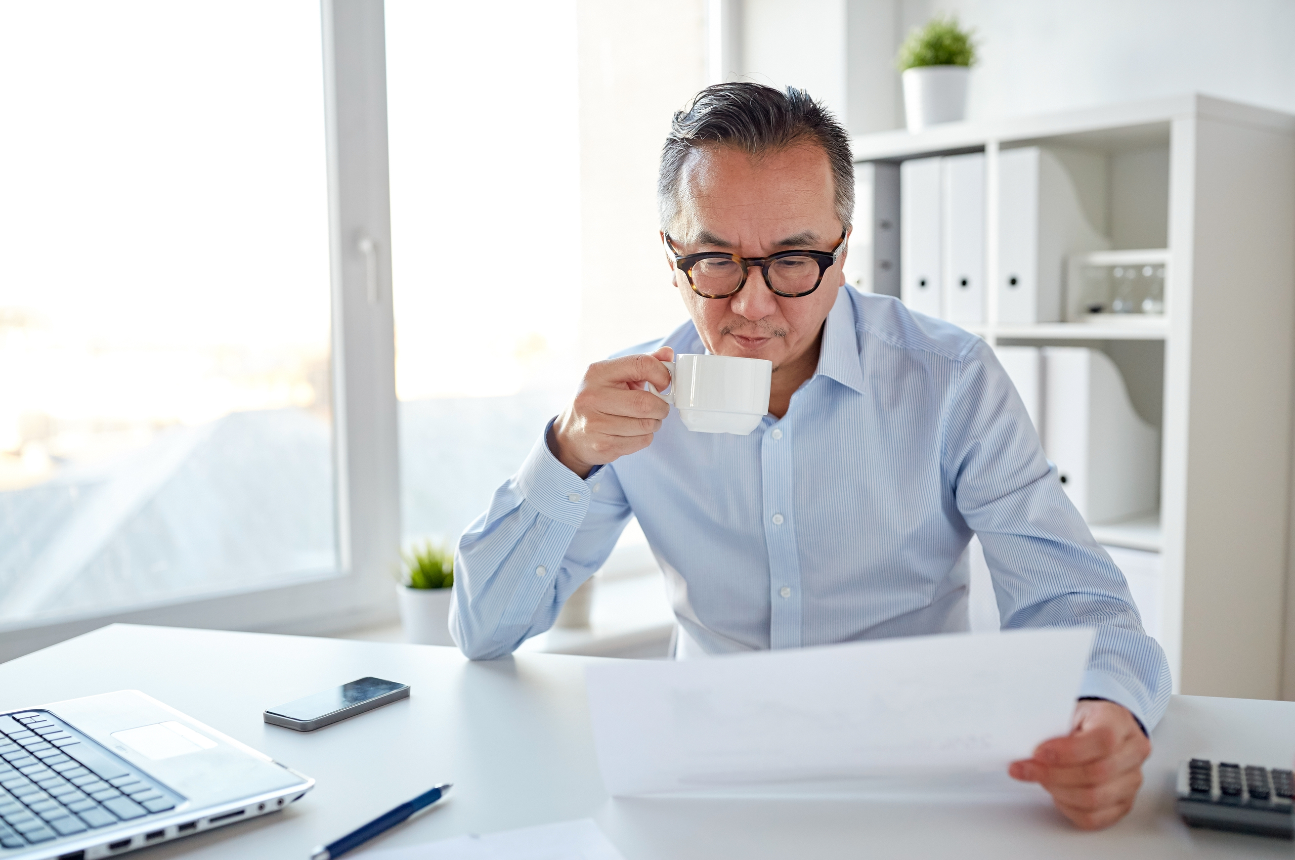 businessman drinking coffee and reading documents