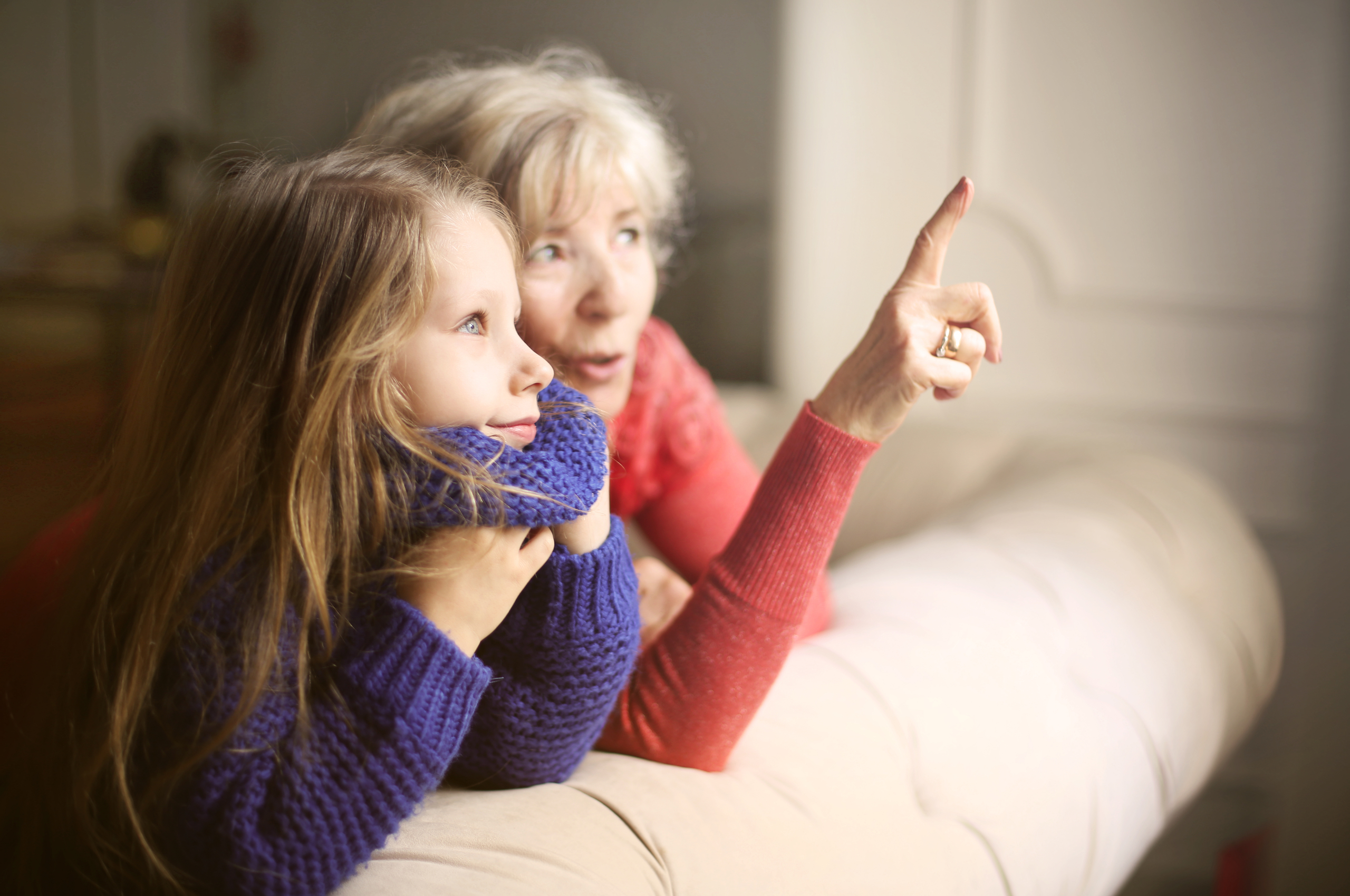 grandmother pointing out something to granddaughter