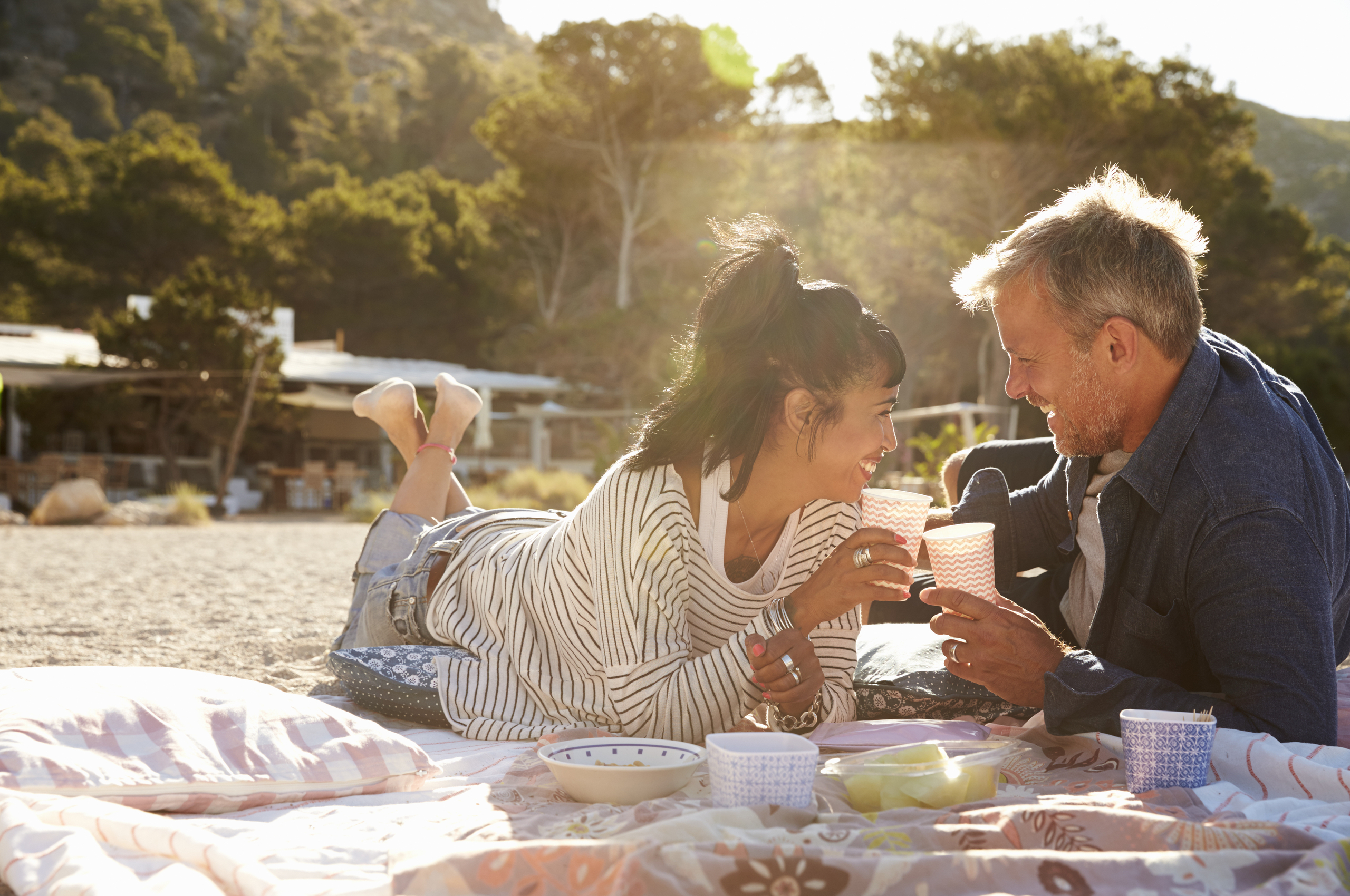 middle-aged couple having a picnic on the beach