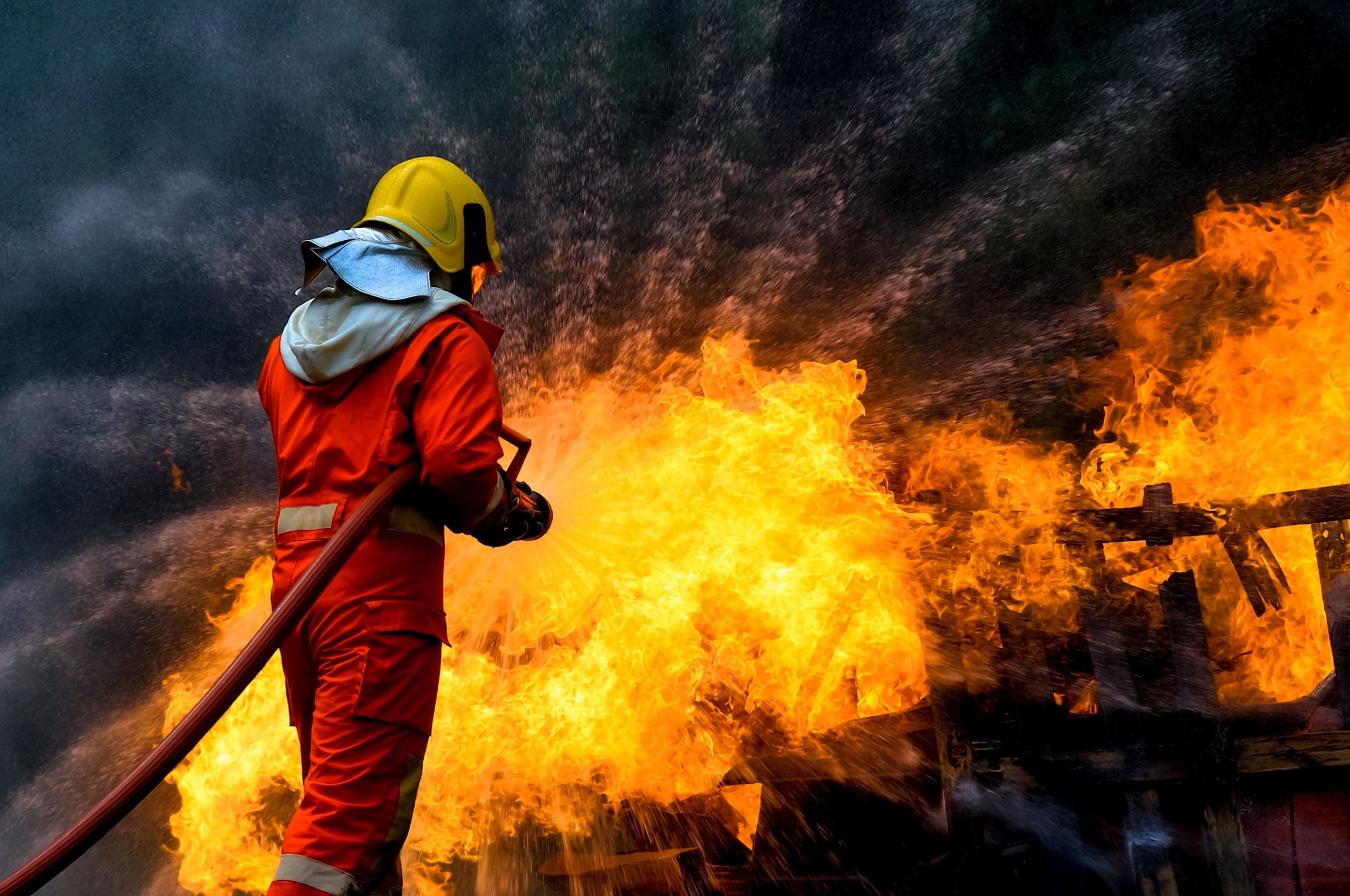 A firefighter spraying down a fire with a hose