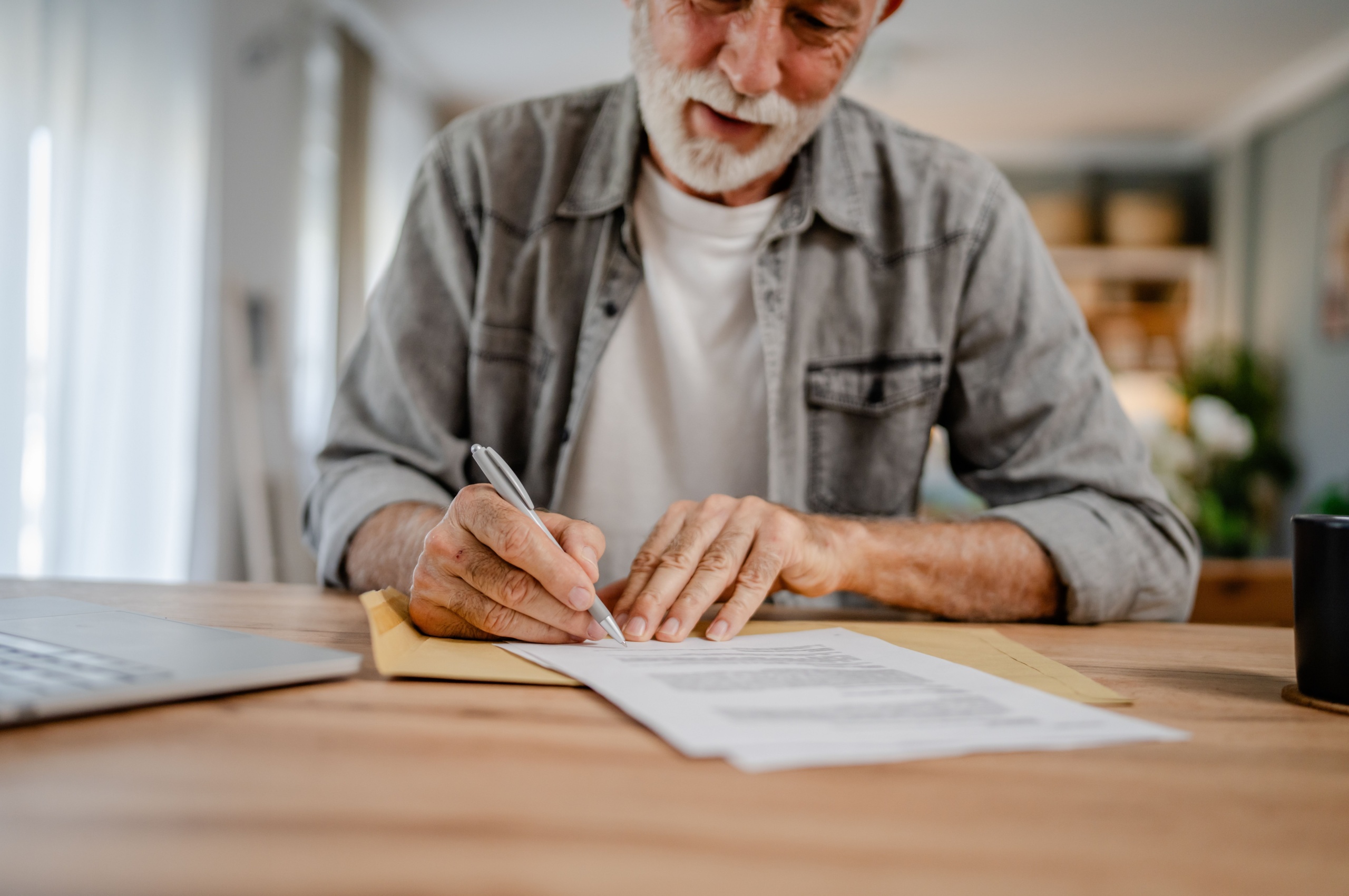 An older man signing a document